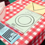 A sample book tasting place setting, including a placemat, napkin, menu, and chef's hat.